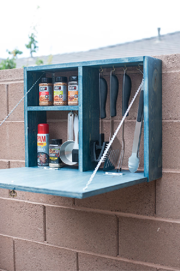 Grill Organization Stations in a wooden counter on a brick fence with spices and barbecue tools