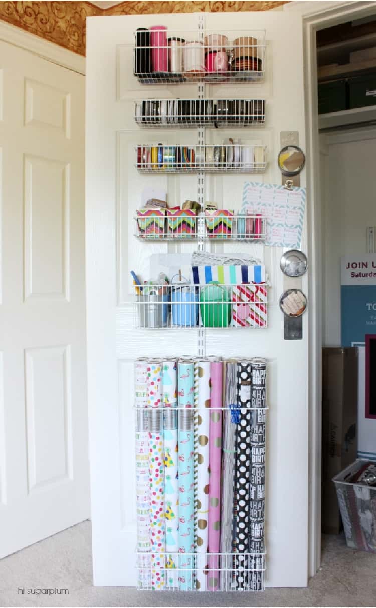 Craft Organization Station with wire baskets on a wooden door filled with ribbons and paper wrap