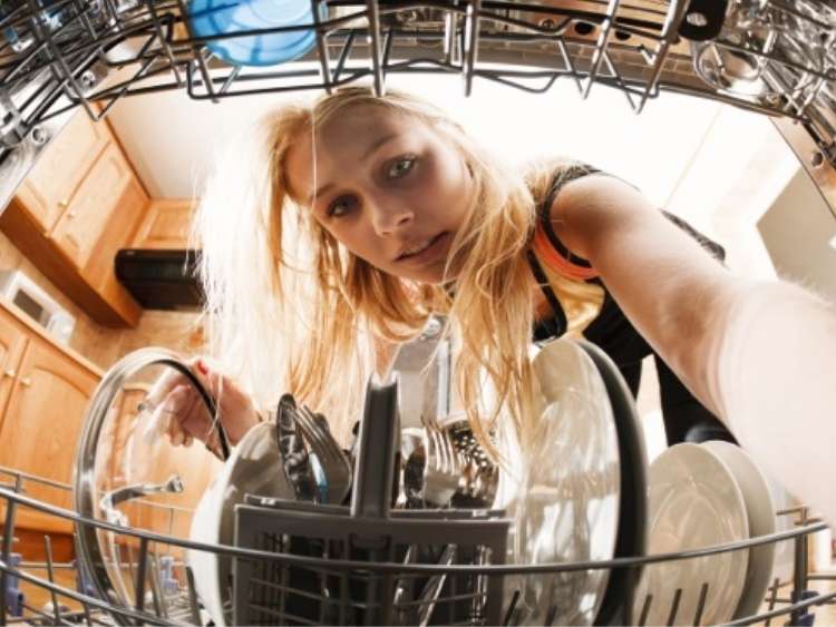 woman reaching into a dishwash