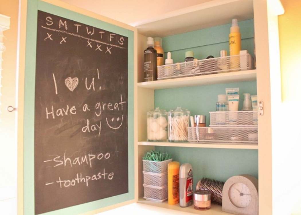 inside view of medicine cabinet with blackboard on the door and shelves organized nealtly