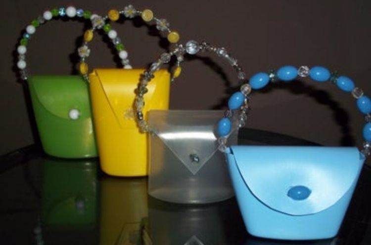 Kids craft play purses from folded soap bottles, wires, and beads.