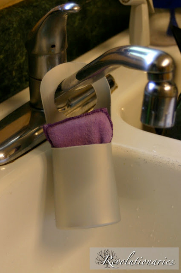 Cut the top and front off an old shampoo bottle and a long back with a whole in it to slip over your sink faucet to hold your sponge. 