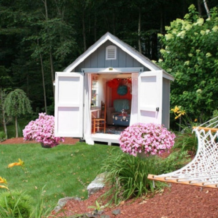 Cheery little shed with double open doors and little couch with decor. 