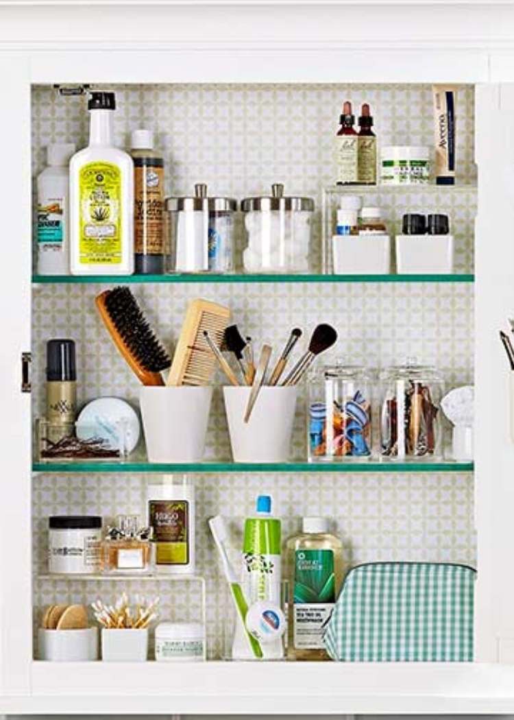 Inside of a medicine cabinet neatly organized with jars and cups