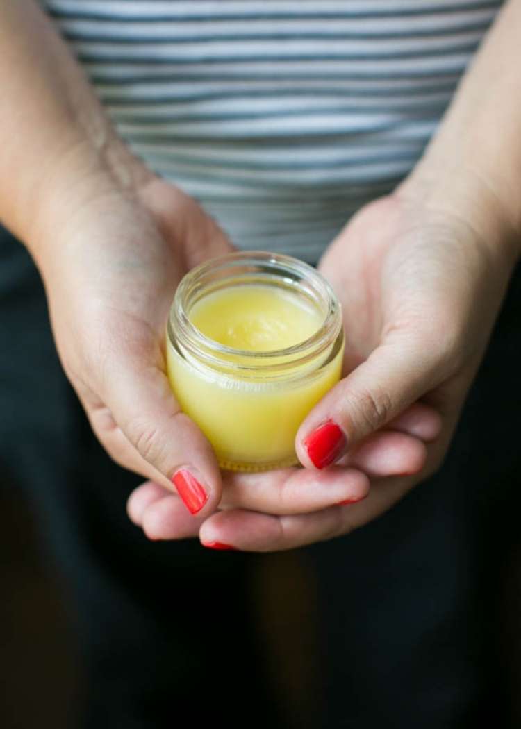 body balm in a cupped hands of a white woman