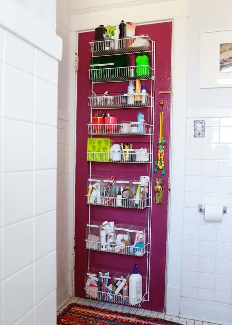 a door hanging organizer ont eh back of the bathroom door, each shelf neatly organized