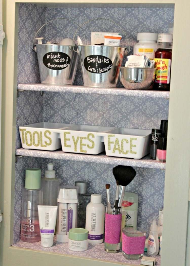 medicine cabinet organized with mini buckets and trays, each labelled with its contents