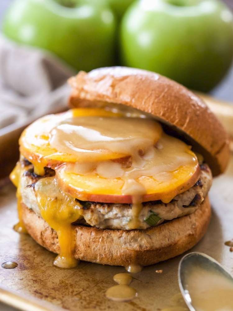 Turkey burger topped with apple slices, cheddar, and a maple dijon mustard.