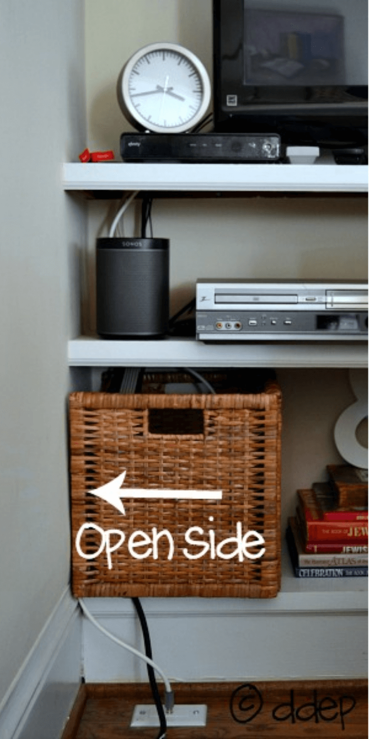 A basket on a shelf used to manage cables and hide wires