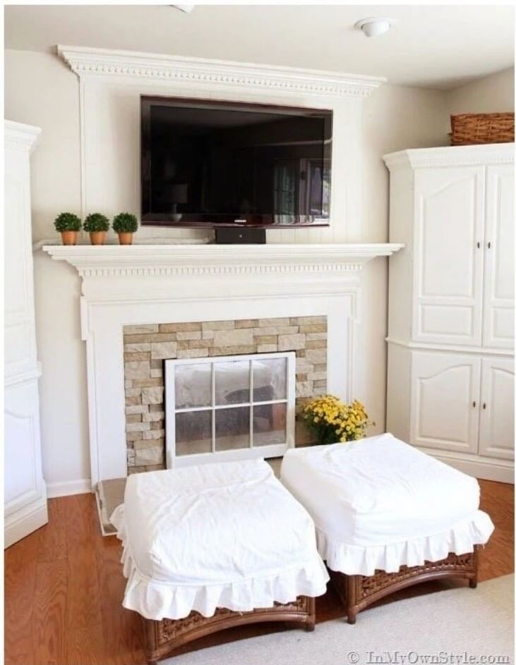 Cable management in a living room by wrapping tv cords in fabric that matches the cream colored wall paint