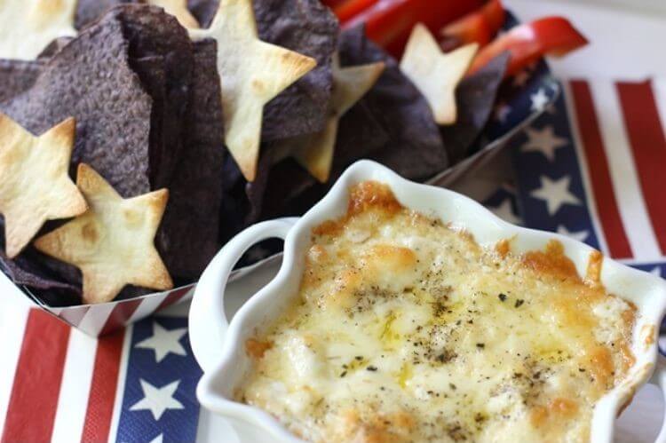 Star shaped pita chips next to a dish of cheese and onion dip