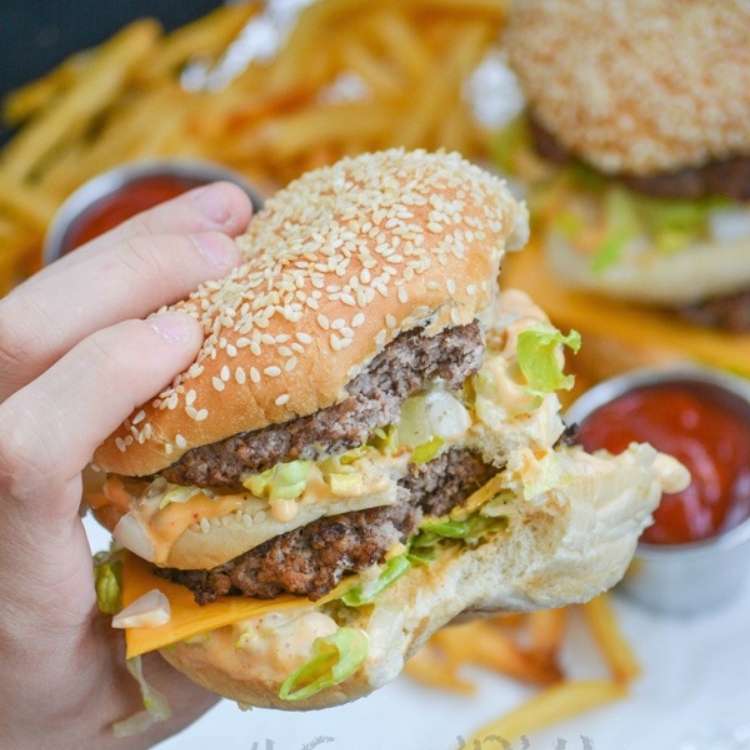 A replica big mac, topped with two patties with a bun inbetween, cheddar, lettuce, and a copy cat big mac sauce.