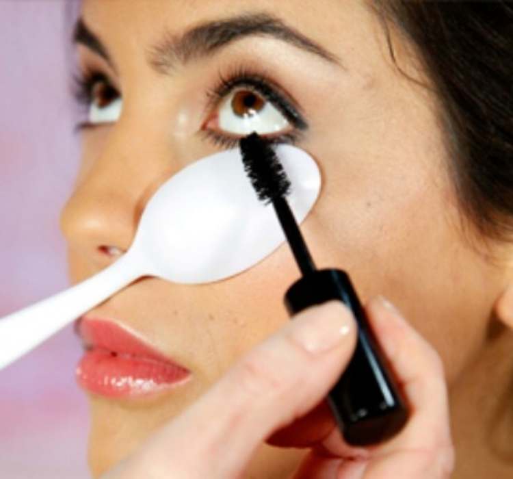 Picture of using plastic spoon to keep mascara from smudging 