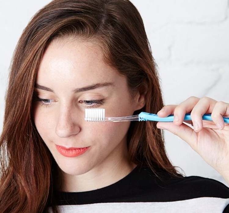 Picture of clean toothbrush being used to unclump mascara
