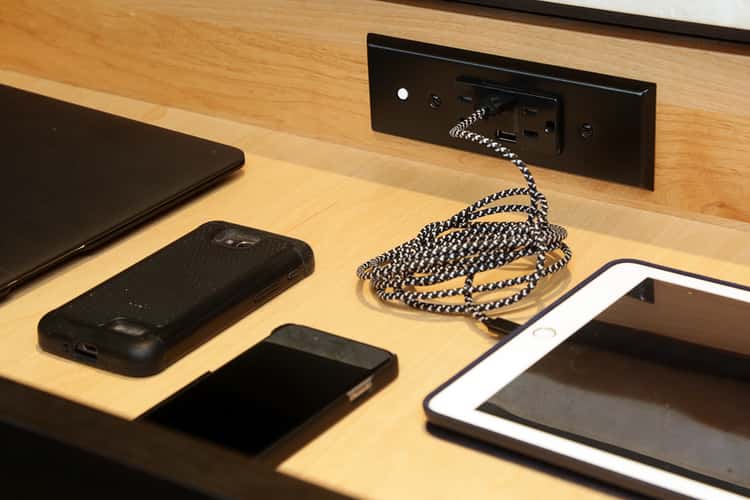 clever organization ideas with a docking station inside a drawer with ipad plugged in and laptop, and two phones next to it.