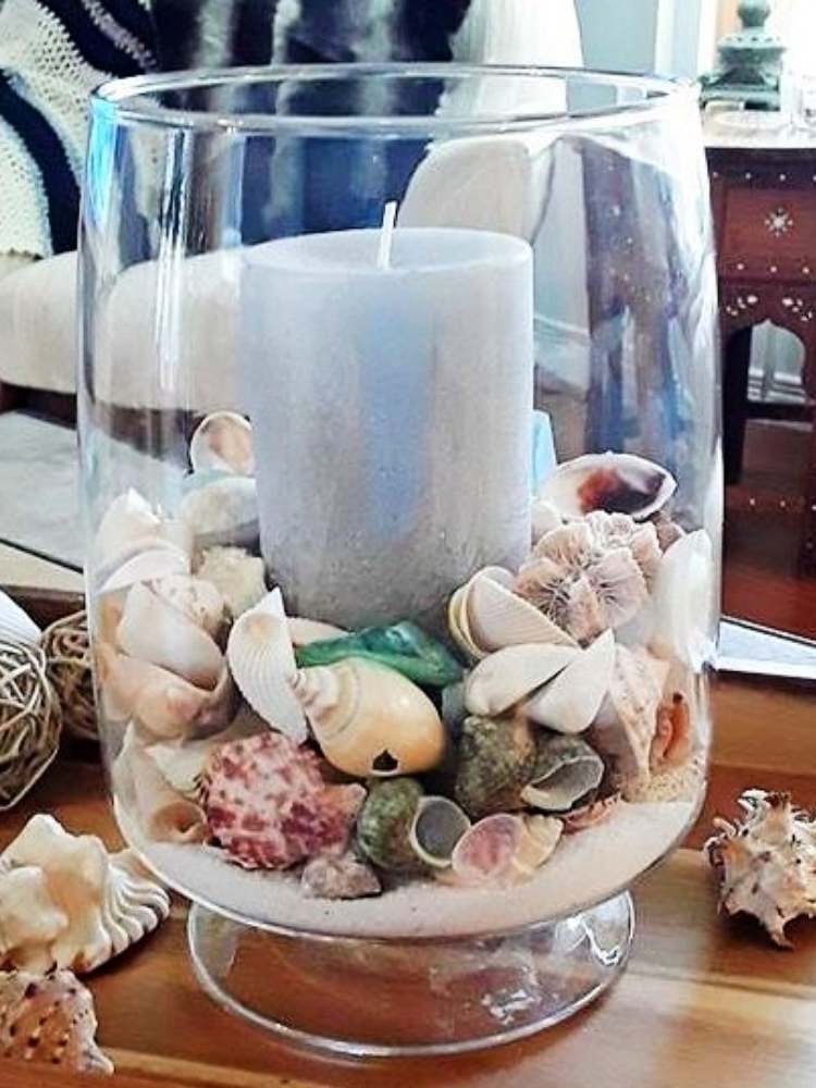 Picture of sand, seashells, and candle in vase