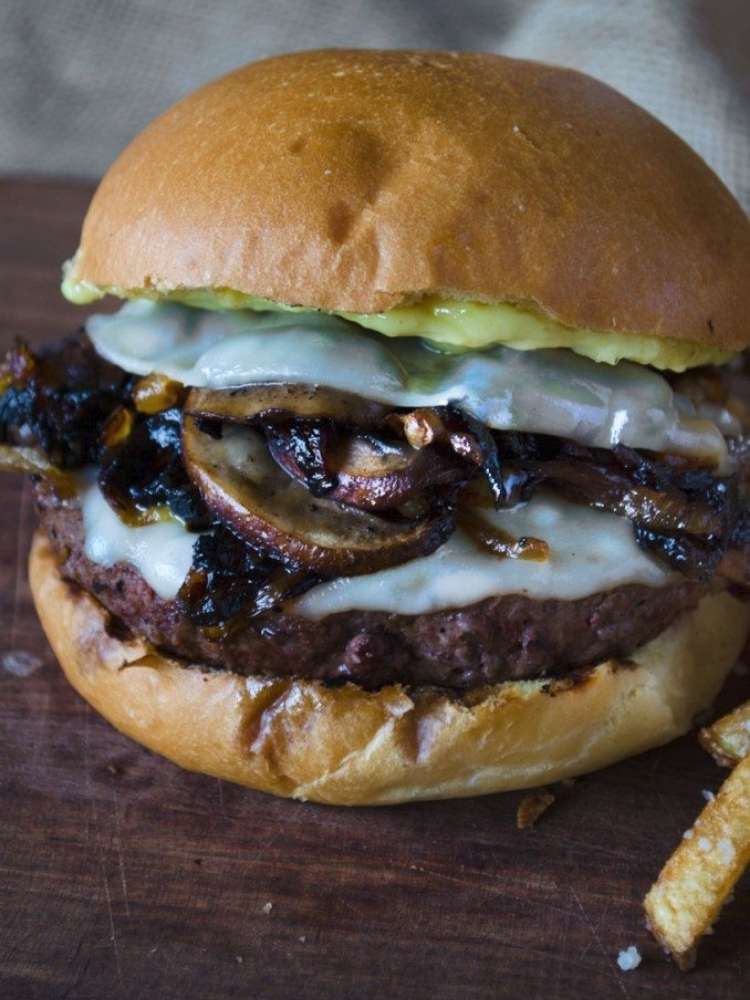 Beef burger topped with grilled mushrooms, provolone, and an avocado sauce.