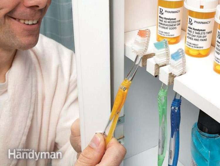 OneCrazyHouse DIY Home Organization open medicine cabinet with a man smiling and reaching for a toothbrush that is stored in small opening on the medicine cabinet shelf