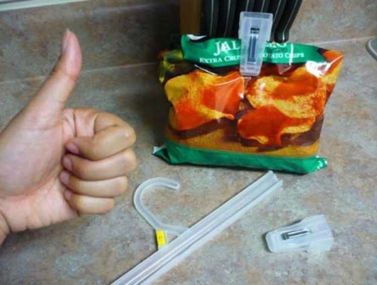 OneCrazyHouse DIY Home Organization hand in a thumbs up in front of a counter with a clip hanger cut ito peices. Clip part of the hanger being used to close a bag of chips