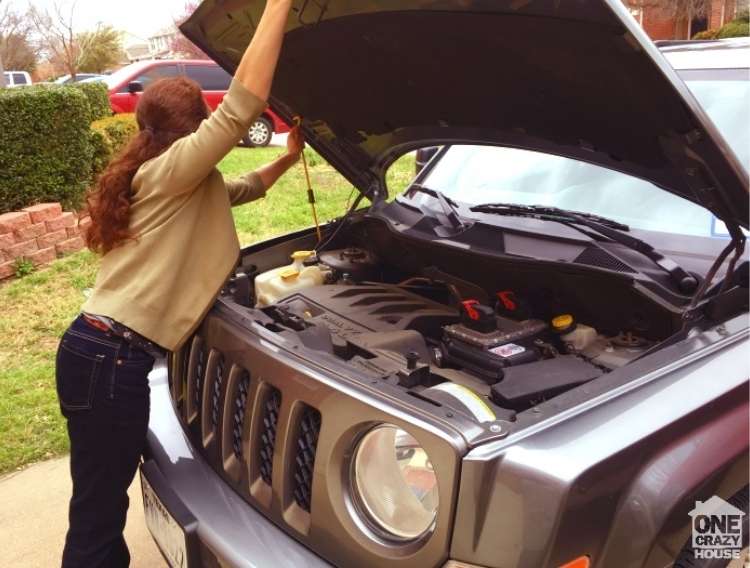 OneCrazyHouse Easy Car Repairs woman holding car hood open and extending the leg to keep it up to repair something in the car engine