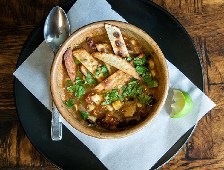 One Crazy House Instant Pot Dinners bowl of chicken tortilla soup on napkin with a spoon next to it