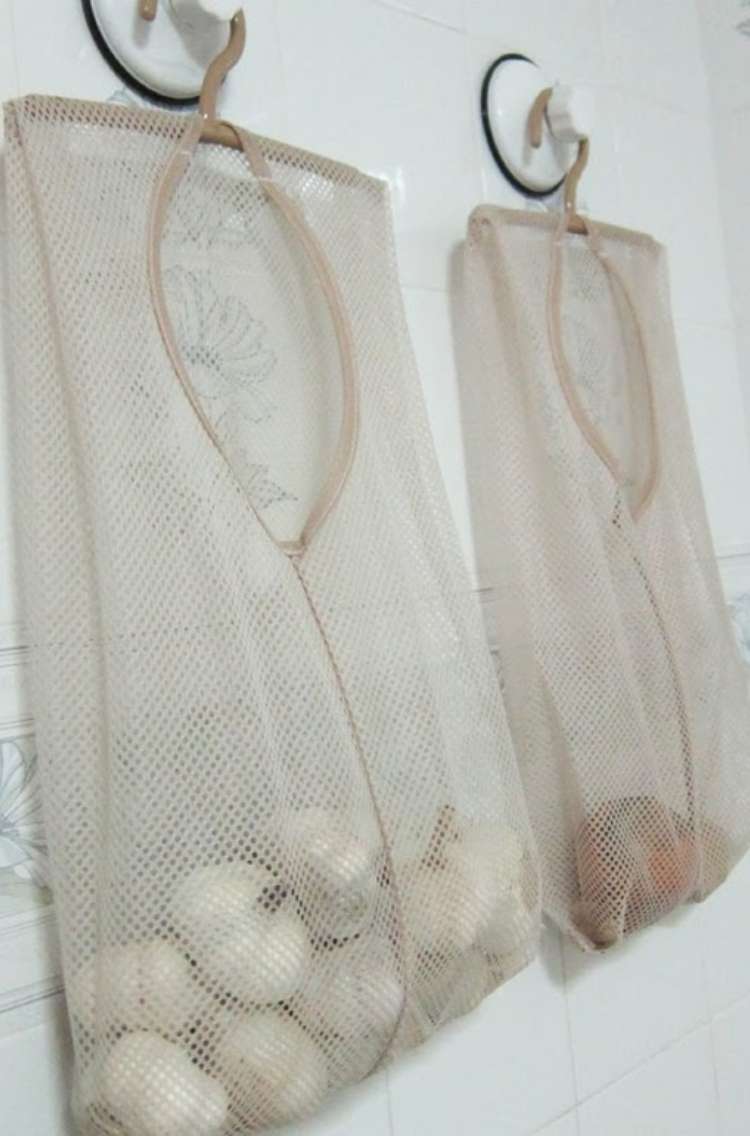 OneCrazyHouse Mesh Laundry Bags Mesh Bags hung from wall. One of the mesh bags has garlic, the other has potatos