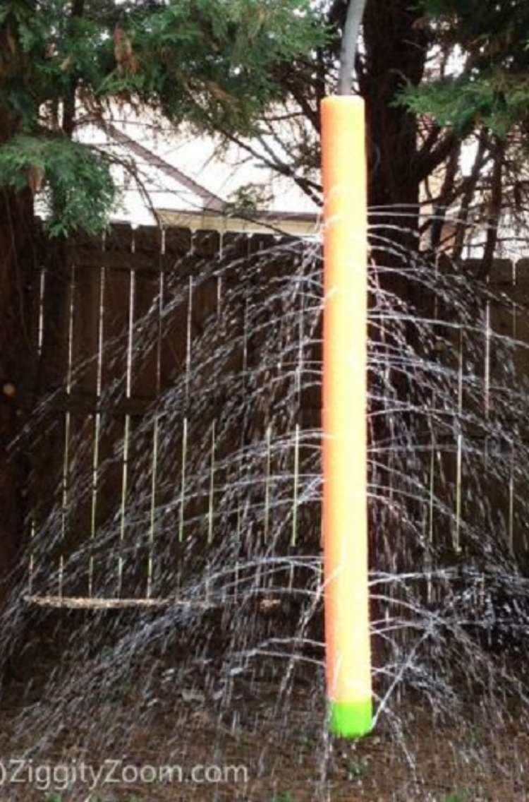 OneCrazyHouse Stay Cool without a pool pool noodle with holes hanging from tree with water pouring out of holes