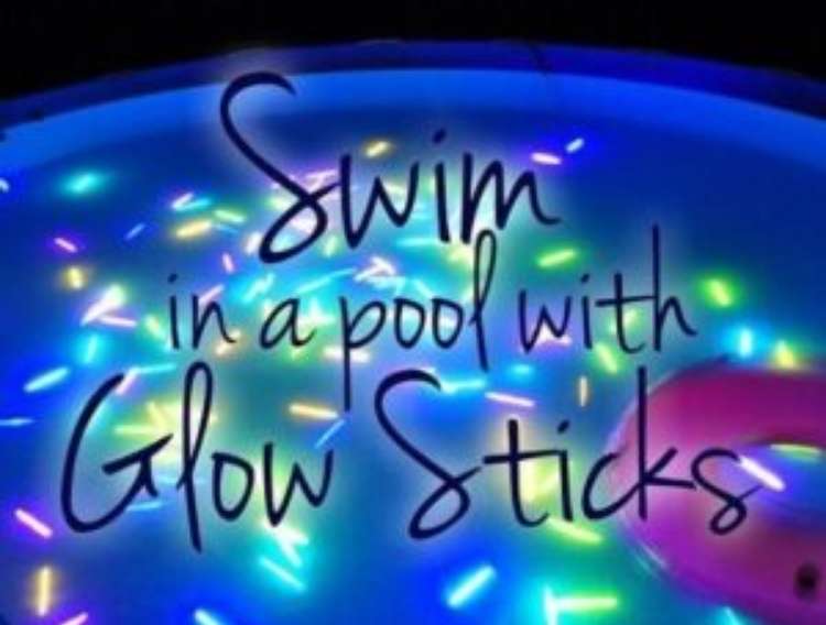 OneCrazyHouse pool storage shot of pool at night with glow sticks thrown inside with text on top that says "swim in a pool with glowsticks"