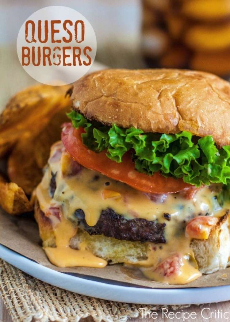 Beef burger topped with lettuce, tomato, and queso sauce. 