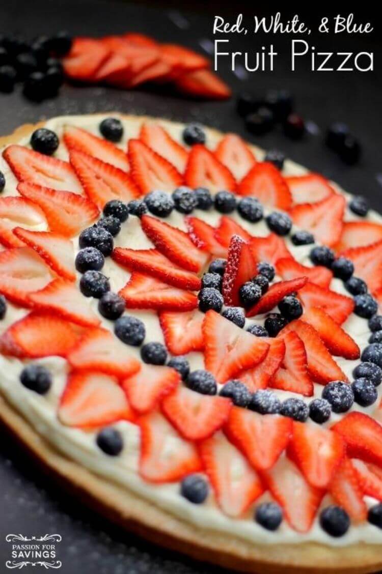 Fruit pizza with sliced strawberries and blueberries on top - 4th of July food idea