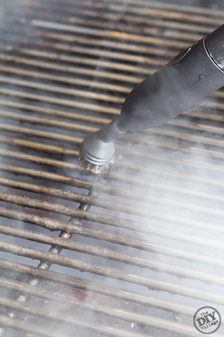 Using the wire brush attachment on steam cleaner to scrub the grill