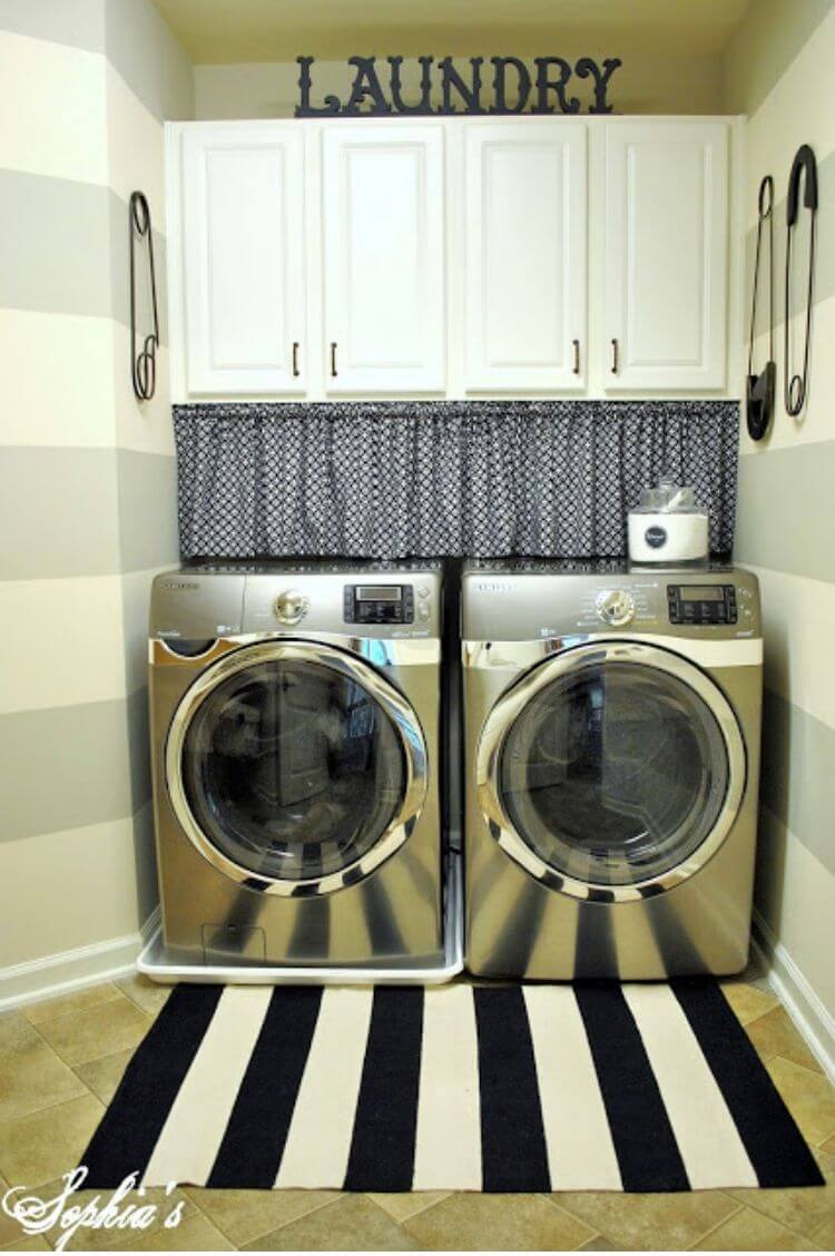 Laundry room with a valence and tension rod covering cords above a washer and dryer