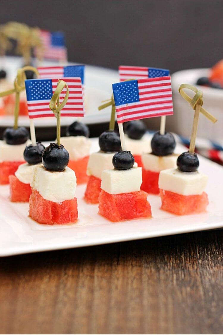 4th of July appetizer using skewers to hold together cut up watermelon, mozerella cheese, and blueberries