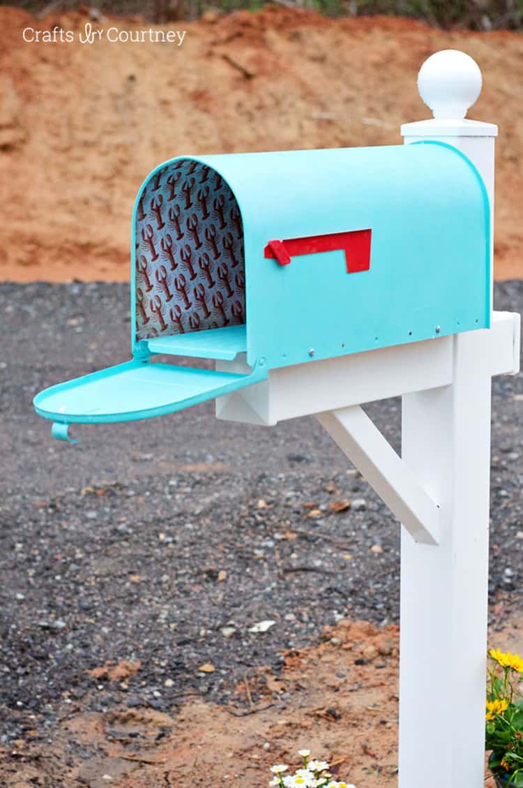 Mailbox painted on the exterior in light blue and inside covered in lobster scrapbook paper to give it a coastal vibe makeover