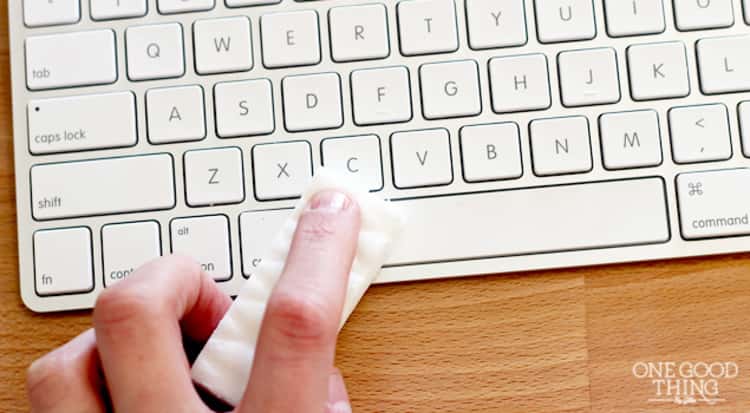 dusting hacks - person's hand seen wiping keyboard with a magic eraser