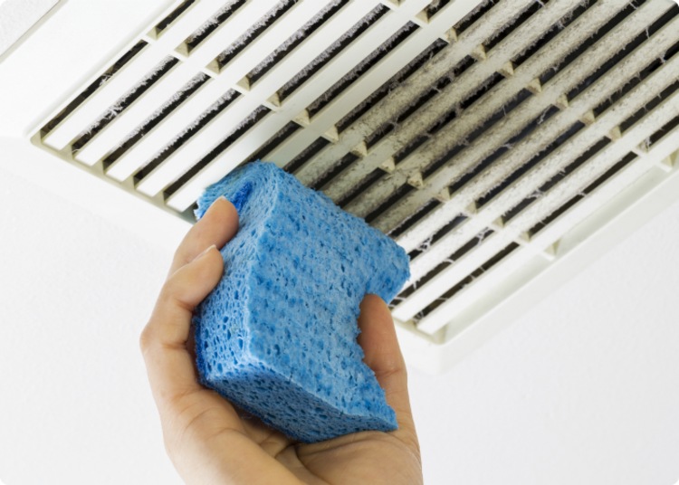 dusting hacks - person cleaning air vent using sponge 