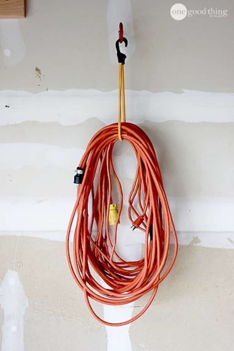 industrial extension cord hung using a bungee cord on a bike hook 