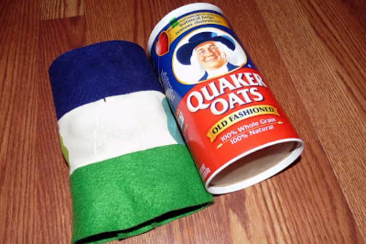 oatmeal container with fabric next to it used as a cover to make it stronger so it can be used for storage