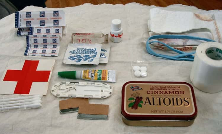 an altoid tin with first aid supplies set neatly beside it ready to put together a first aid kit