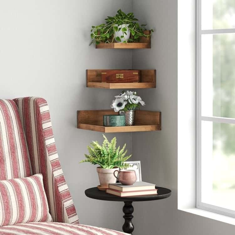 3 wood floating shelves in a corner with plants and a wooden box on top