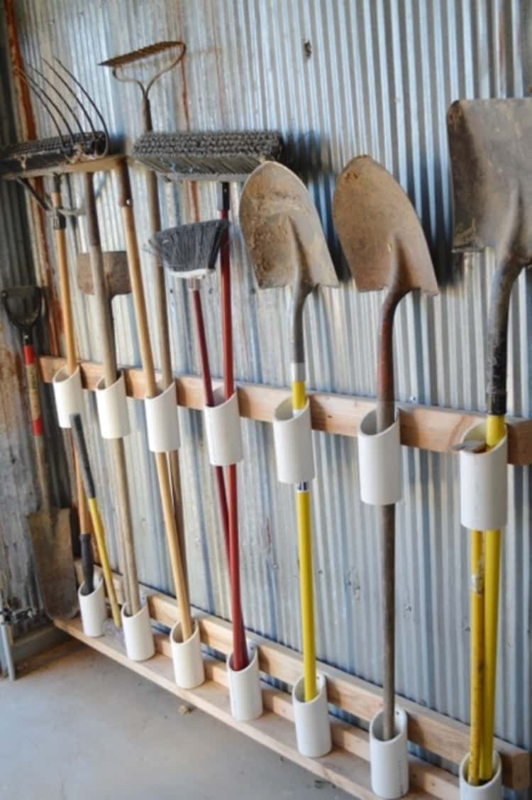 Hanging garden tools upright in the garage with pvc attached to wood pieces