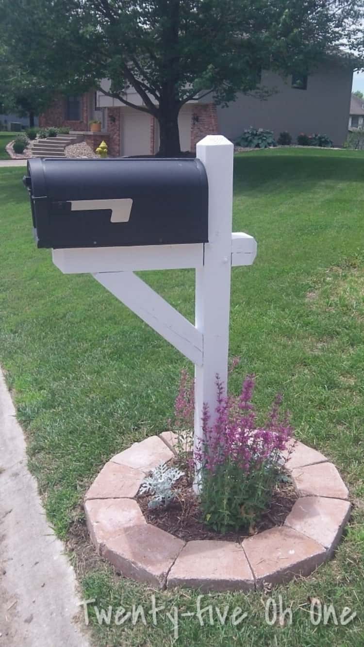 landscaped mailbox makeover with pavers and flowers at its base