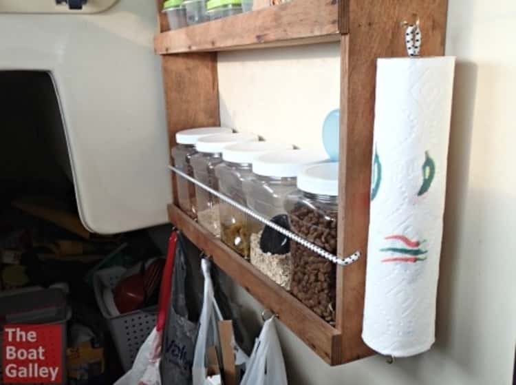 bungee cord uses - an upright paper towel holder made using a bungee cord and attached to a spice shelf