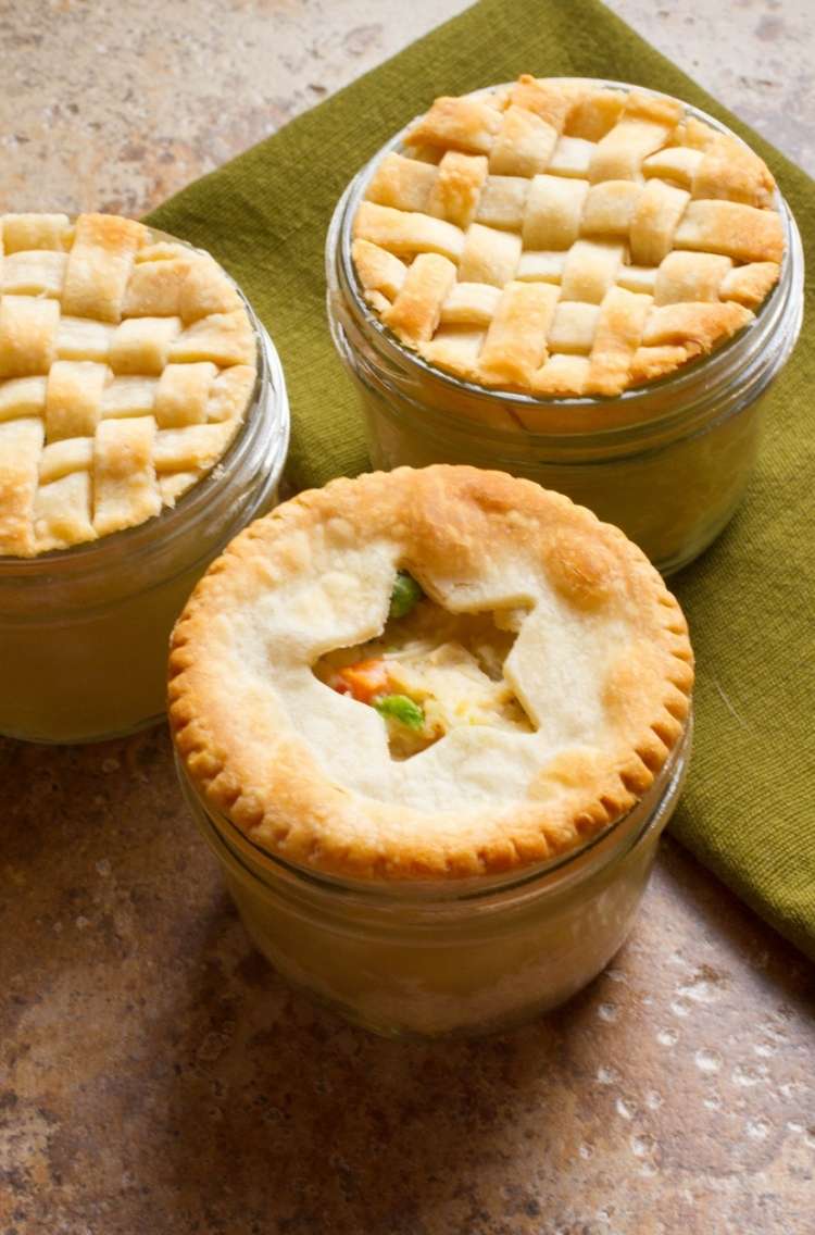 Chicken pot pie: 3 small containers filled with chicken pot pie.- 2 pies covered with woven crust, 1 mason jar pie with a star crust cut-out