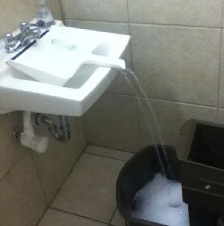 Dustpan in use to funnel water from sink and into the mop bucket 