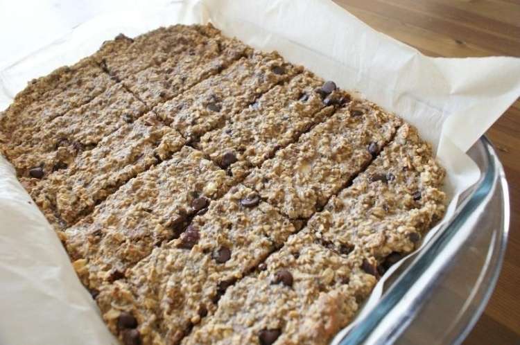 Baking dish with oatmeal bars with chocolate chips on parchment paper in dish