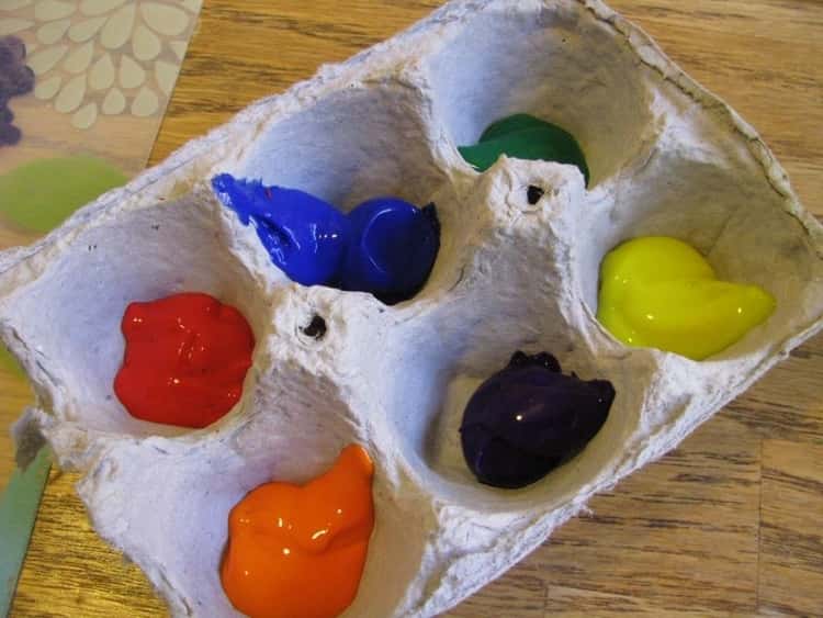 One half of cardboard egg carton in use a as paint palette