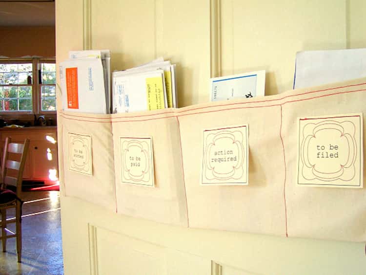 DIY paper sorter hung on the wall with letters inside, beige color