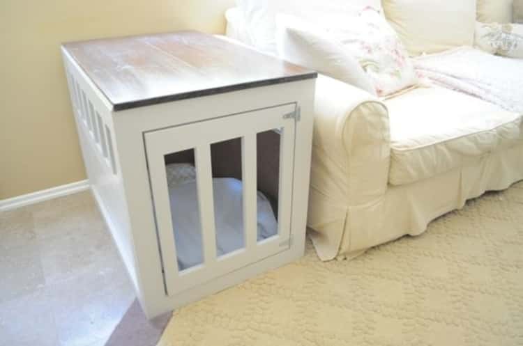 A wooden dog crate doubling as an end table placed at the end of a couch