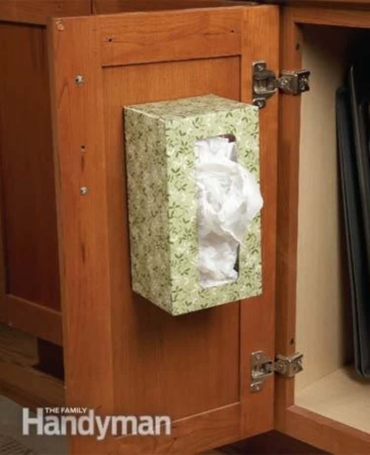 grocery bags stored in empty tissue box attached to the inside of a cabinet door 